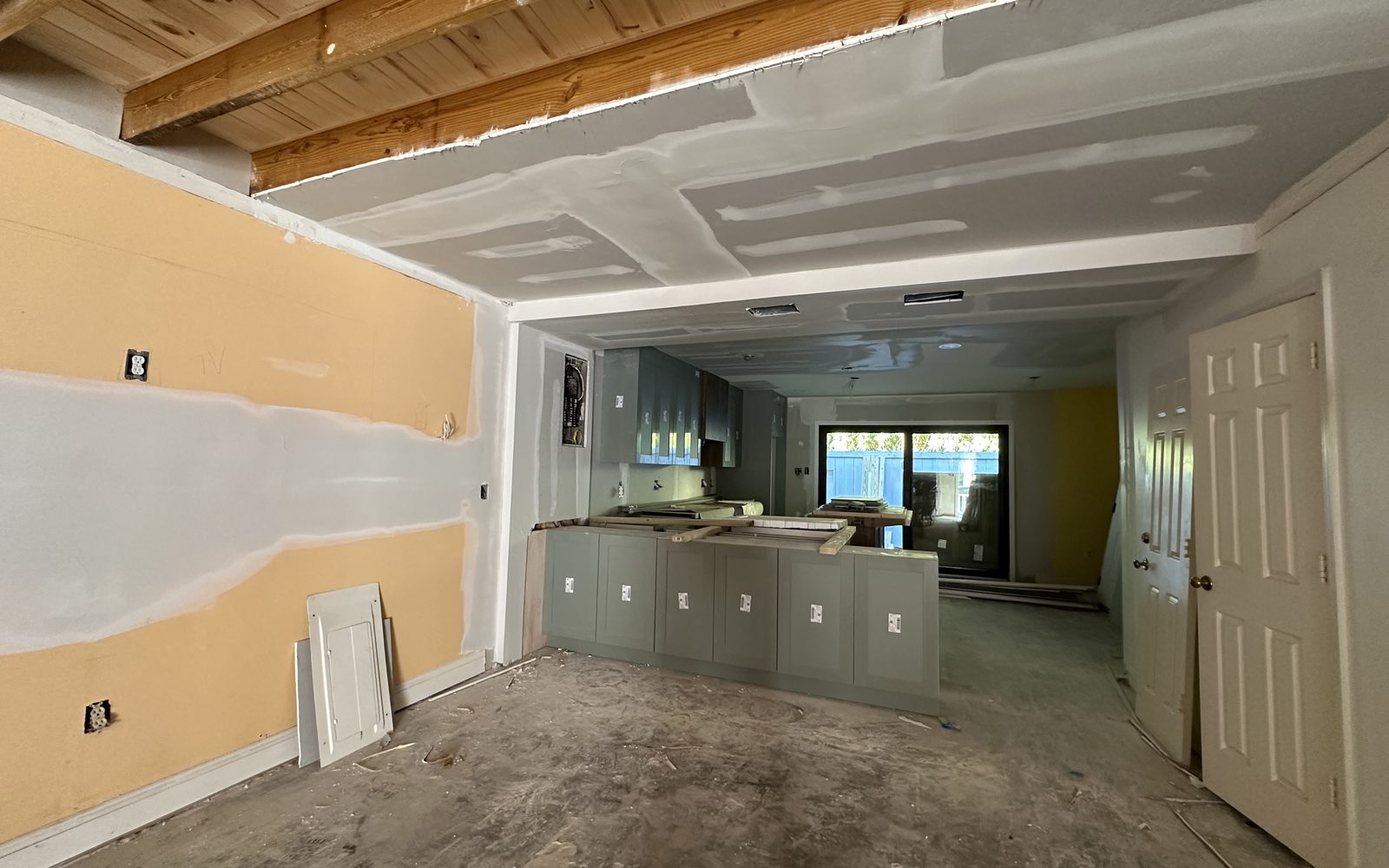Kitchen before restoration: dated cabinets, yellow walls